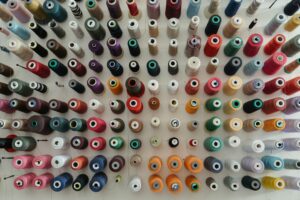 A top-down view of assorted colorful thread spools organized neatly for sewing projects.